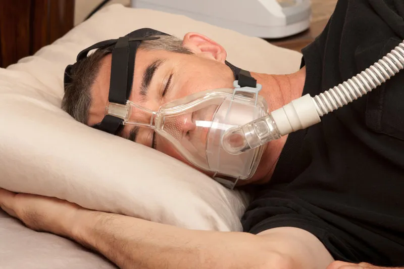 man using CPAP machine for his sleep apnea.